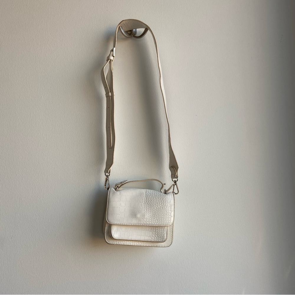 White leather crossbody bag with silver hardware. Strap is detachable.